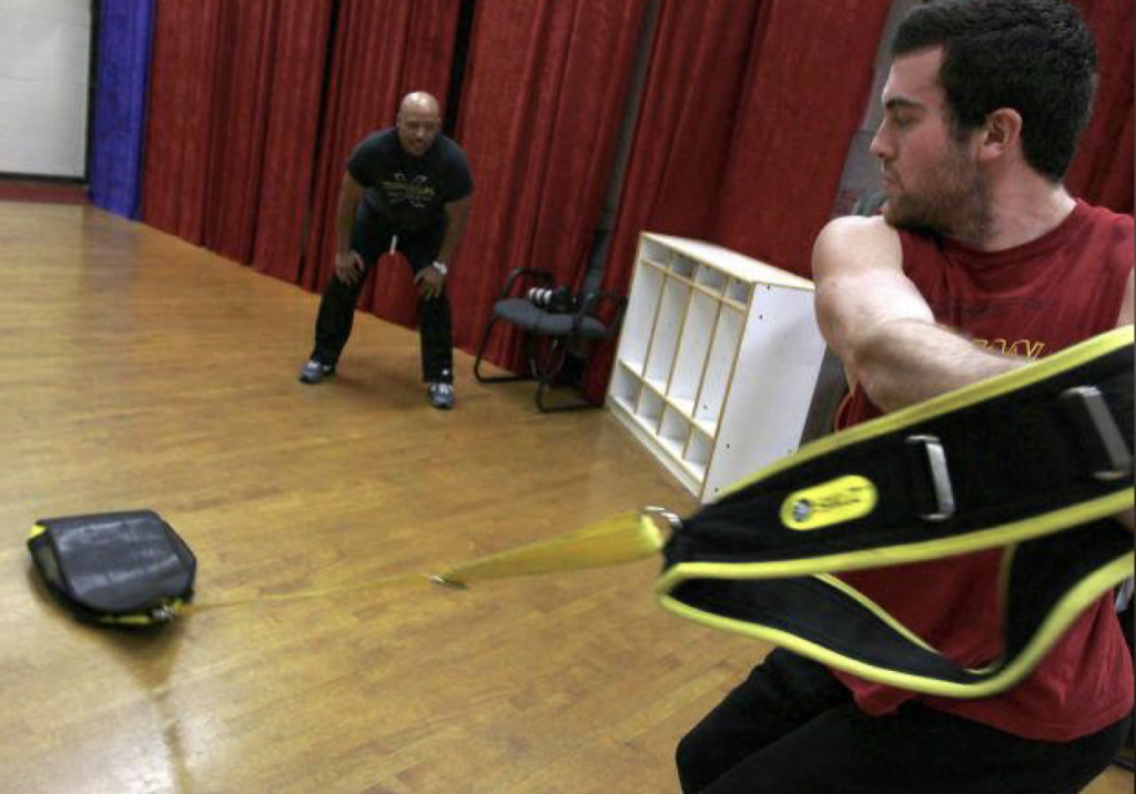 Monte Nash, left, trainer and developer of SpeedSac strengthening equipment, looks on as Travis English, a former St. Joseph high School and Alan Hancock College student athlete, performs a core exercise using the equipment Thursday. Nash will host a free SpeedSac training workshop Saturday at 1 p.m. at the Santa Maria Valley YMCA for student athletes ages 5-13. (Leah Thompson/Staff)